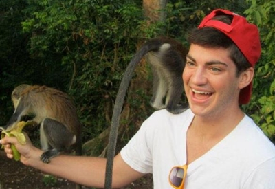 Auburn student with monkeys on his arm and shoulder