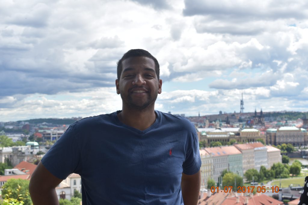 Auburn student abroad in elevated position with city landscape below under cloudy skies